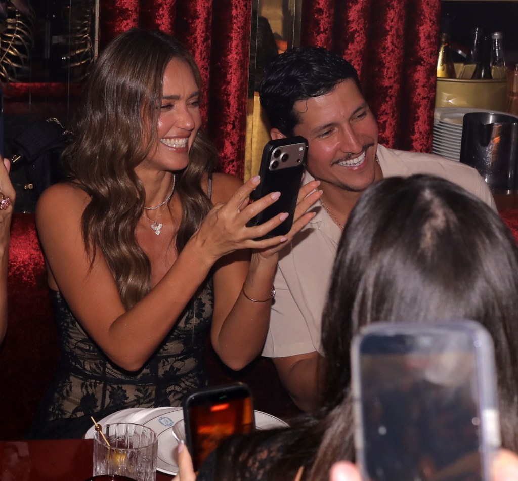 Jessica Alba and Danny Ramirez smile as Alba takes a picture with her phone at Papi Steak in Miami.