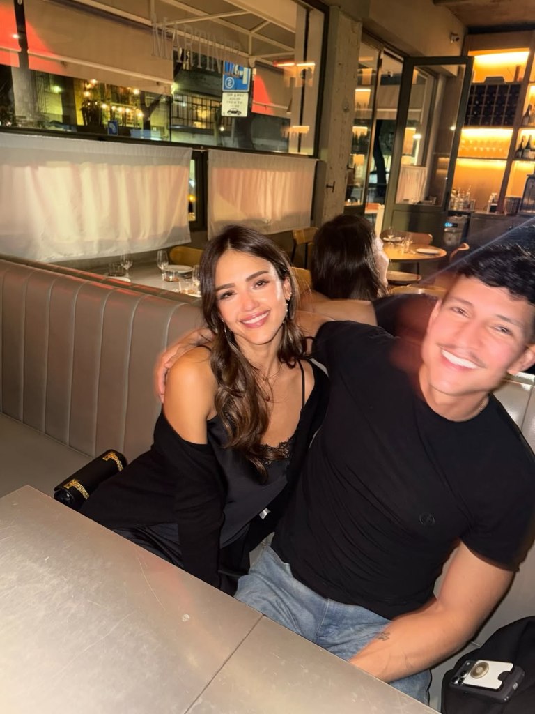 Jessica Alba and Danny Ramirez posing together at a restaurant.