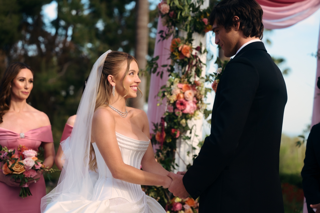 Sydney Sweeney and Jacob Elordi at a wedding, with Jessica Blair Herman in the background.