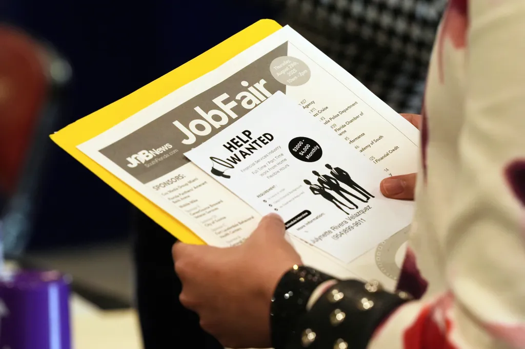 A person holding a flyer for a job fair with 