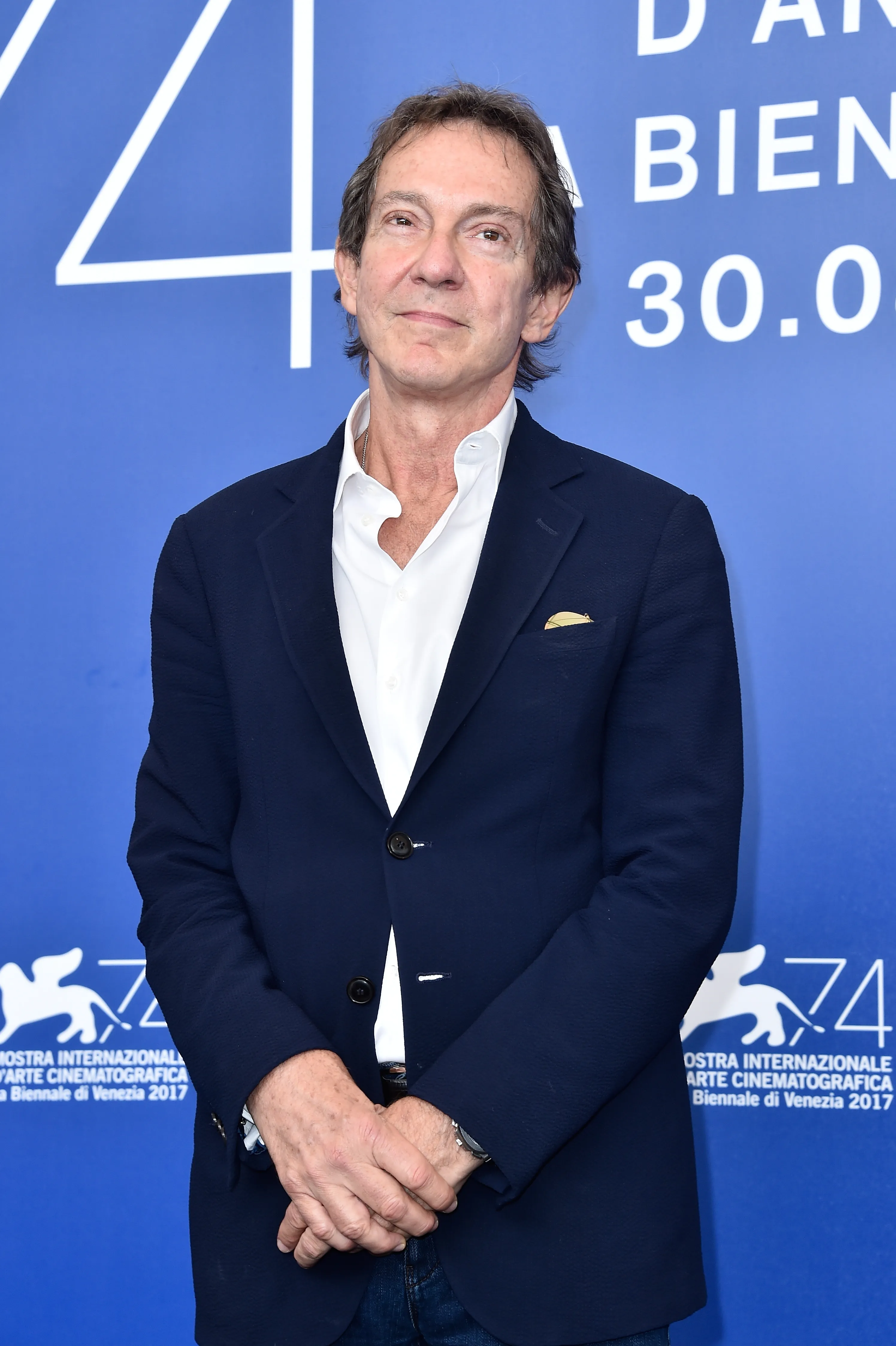 Entertainment attorney John Branca, co-executor of Michael Jackson's estate, wearing a dark blue suit jacket and white shirt at an event.