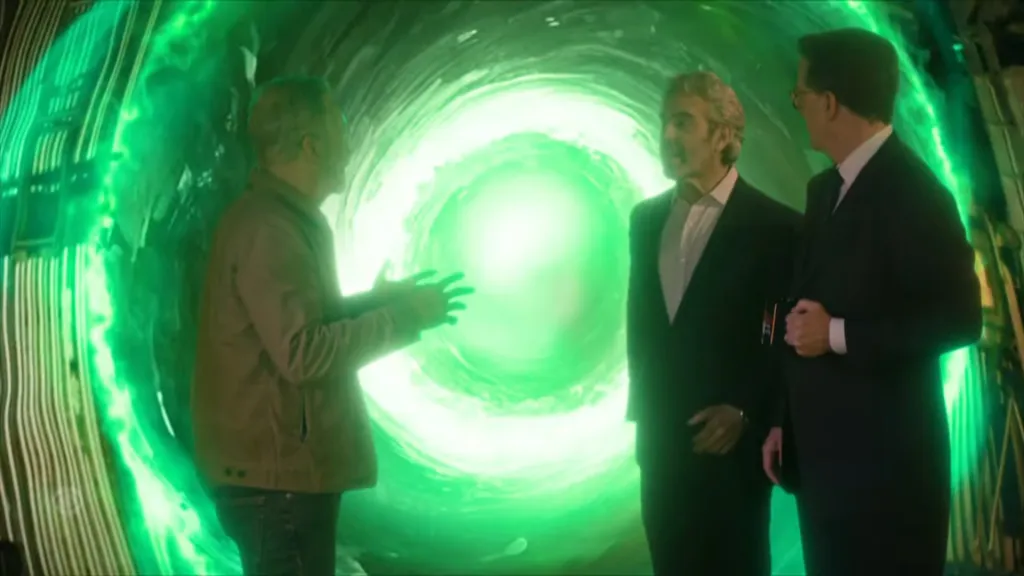 Jon Stewart, Andy Cohen, and Stephen Colbert stand in front of a green swirling vortex on the set of The Late Show.