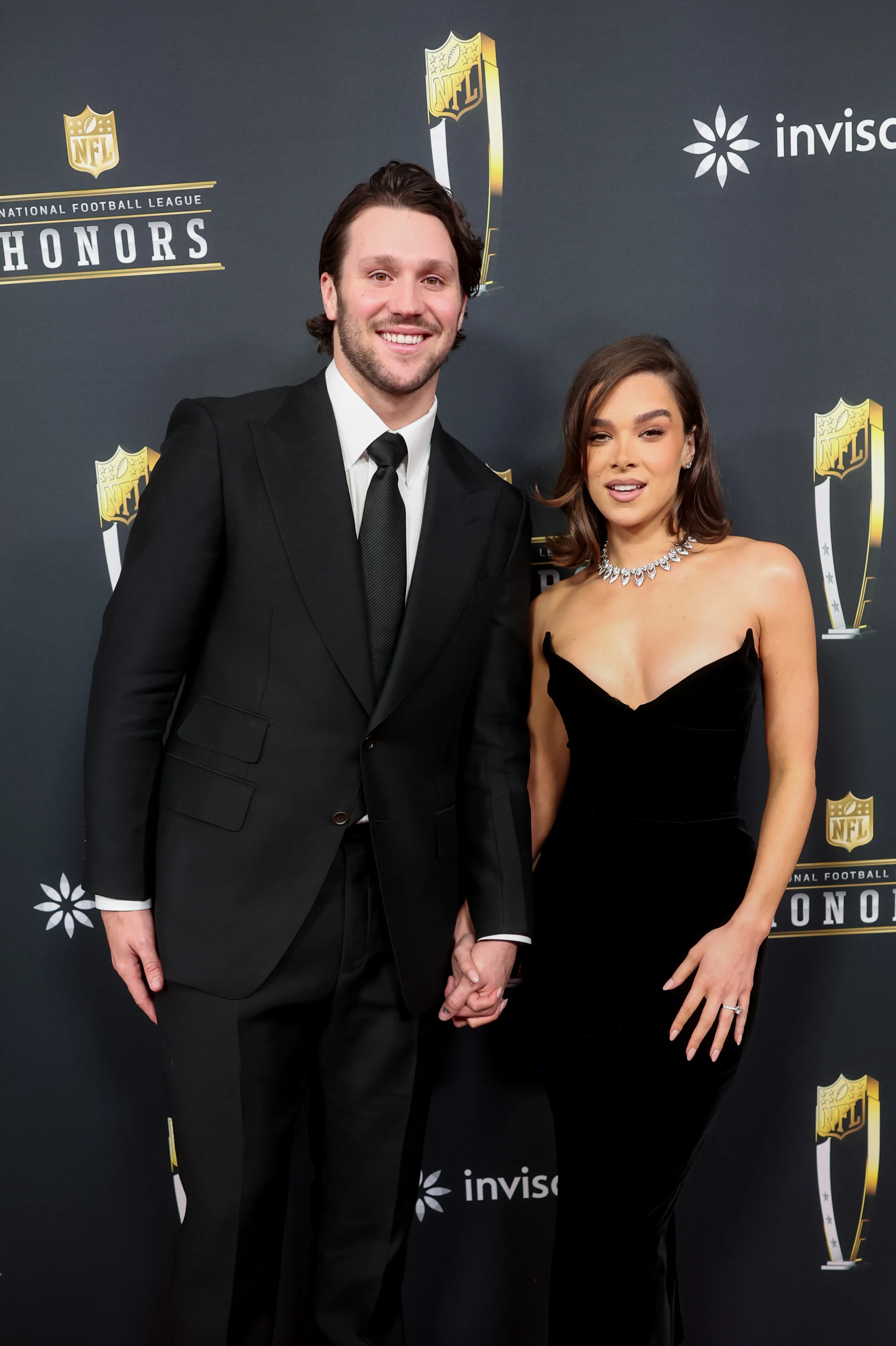 Josh Allen and Hailee Steinfeld smiling and holding hands at the 14th Annual NFL Honors event.
