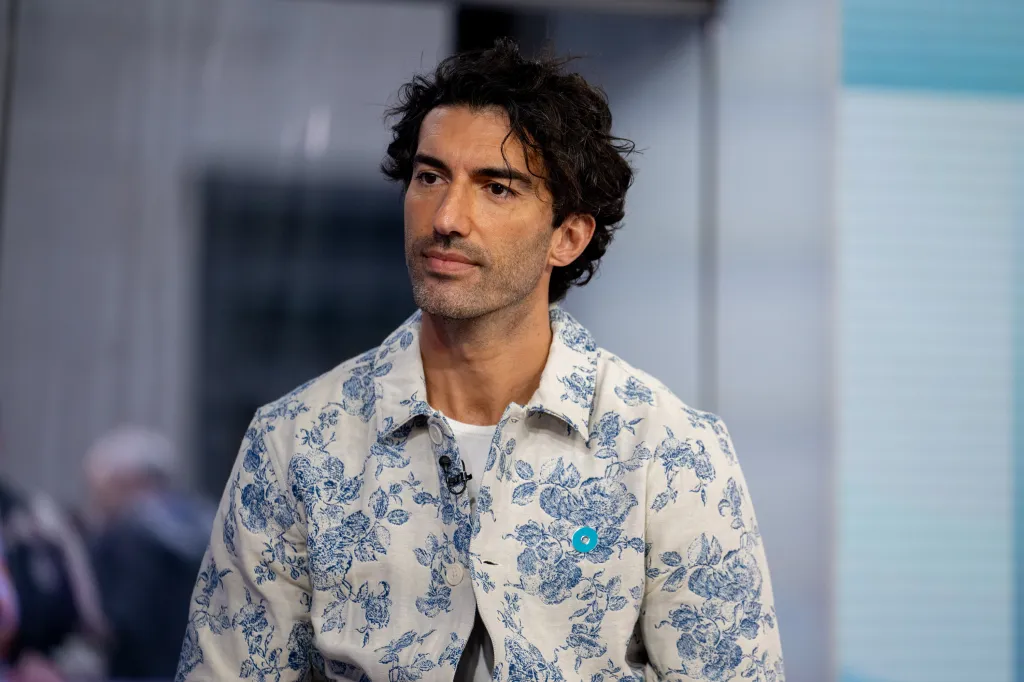 Justin Baldoni wearing a white jacket with a blue floral pattern.