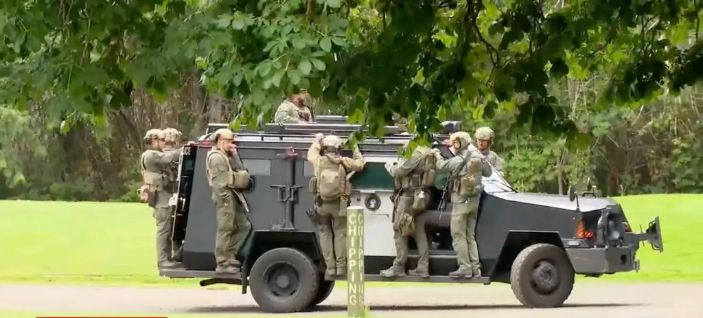 Police officers on an armored vehicle.