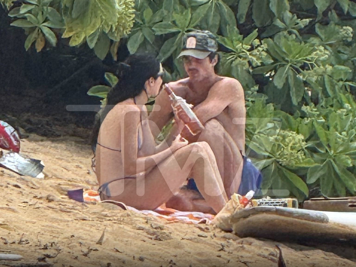 Kendall Jenner and Jacob Elordi sitting on a beach, with Jenner holding a bottle of rosé.