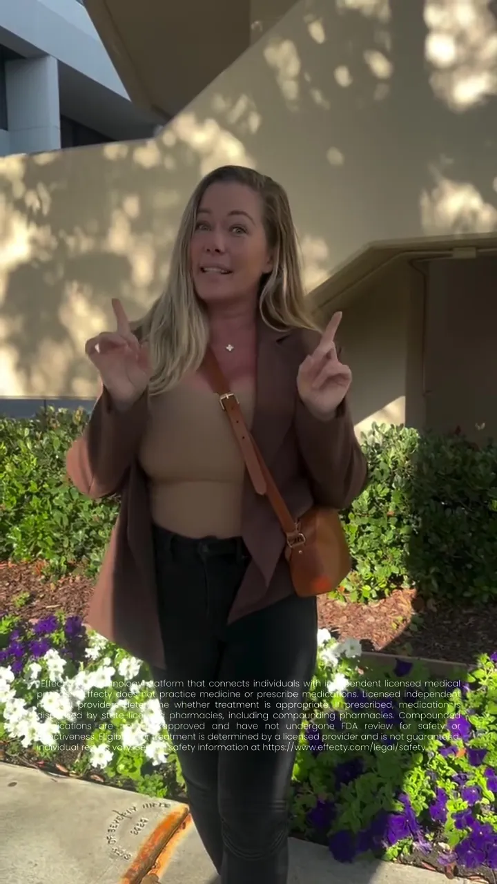 Kendra Wilkinson making hand gestures while standing outdoors.