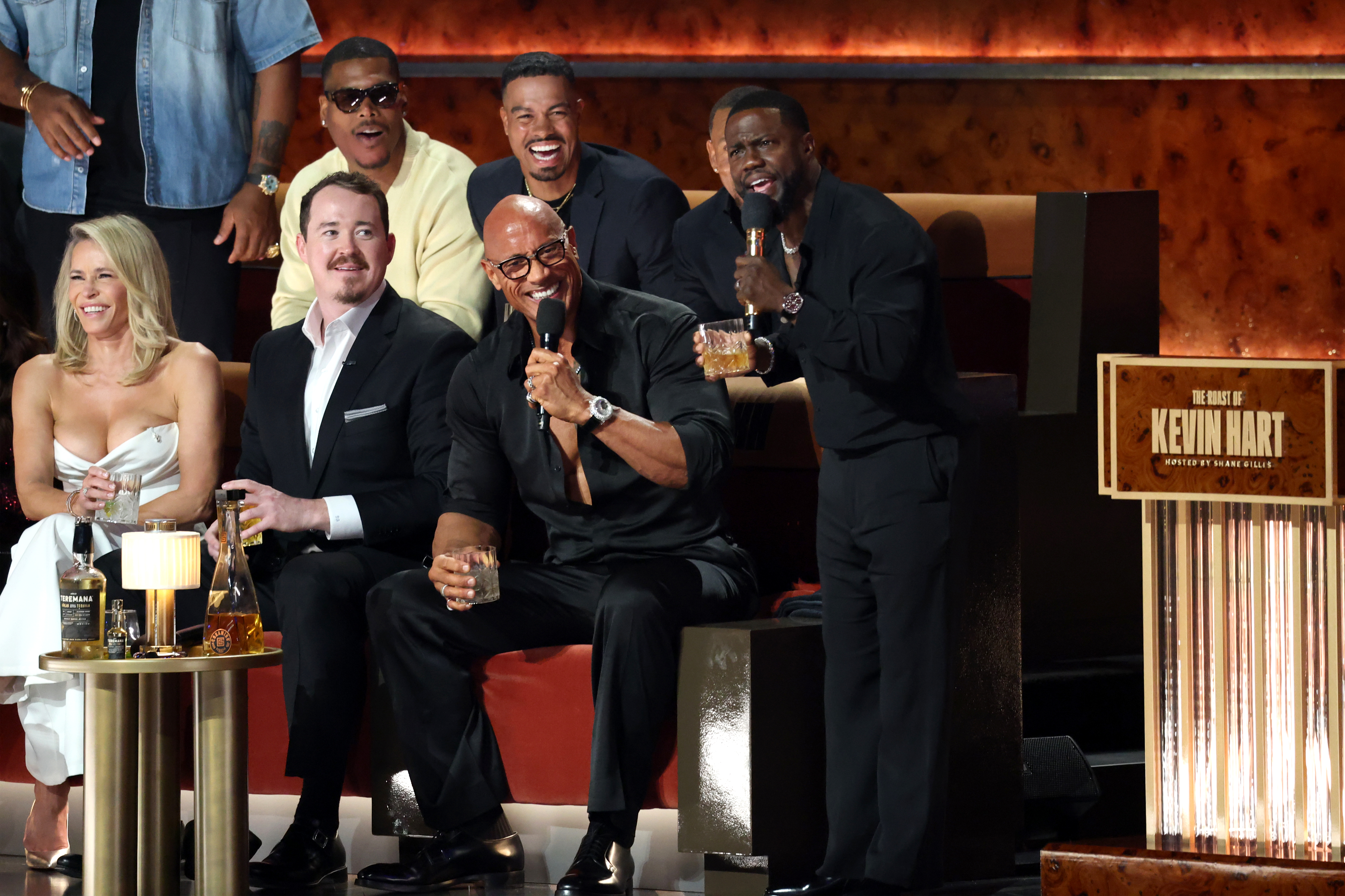 Kevin Hart holding a microphone while Dwayne 