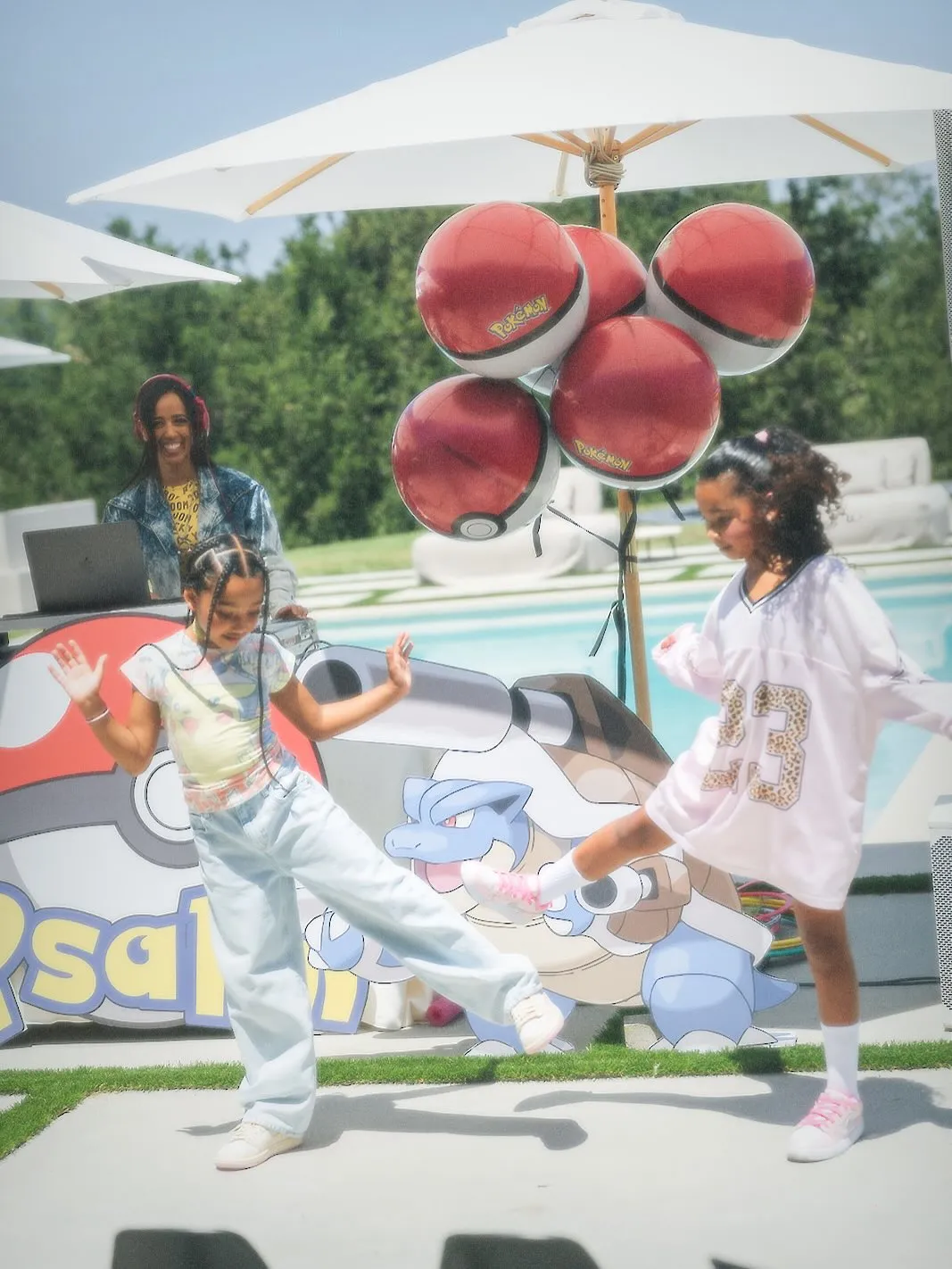 Two girls dancing at a Pokémon-themed birthday party.
