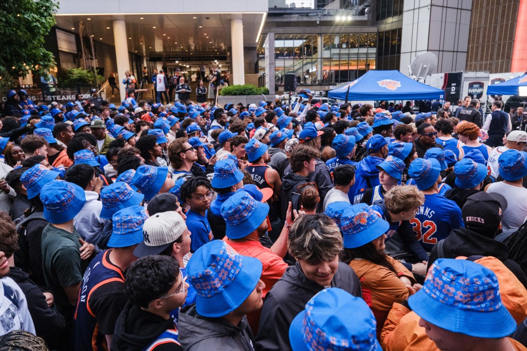 Knicks fans gathered outside Madison Square Garden wearing team apparel.