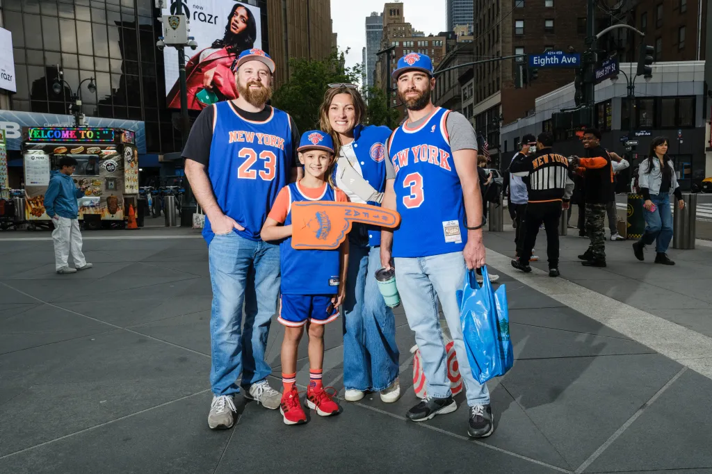 Four Knicks fans pose for a photo before boarding a bus to Philadelphia.