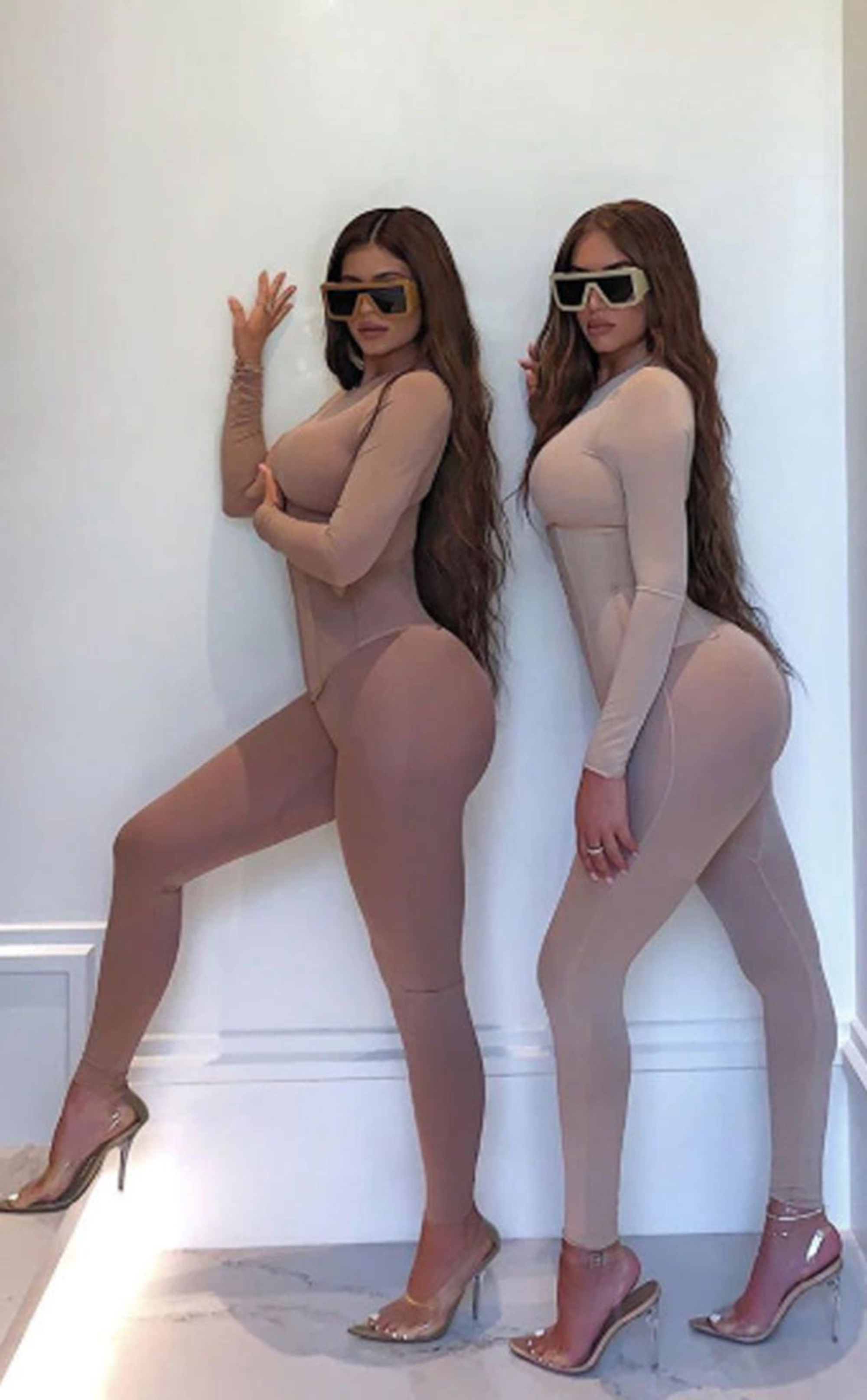 Kylie Jenner and Stassie Karanikolaou posing in matching bodysuits and sunglasses.