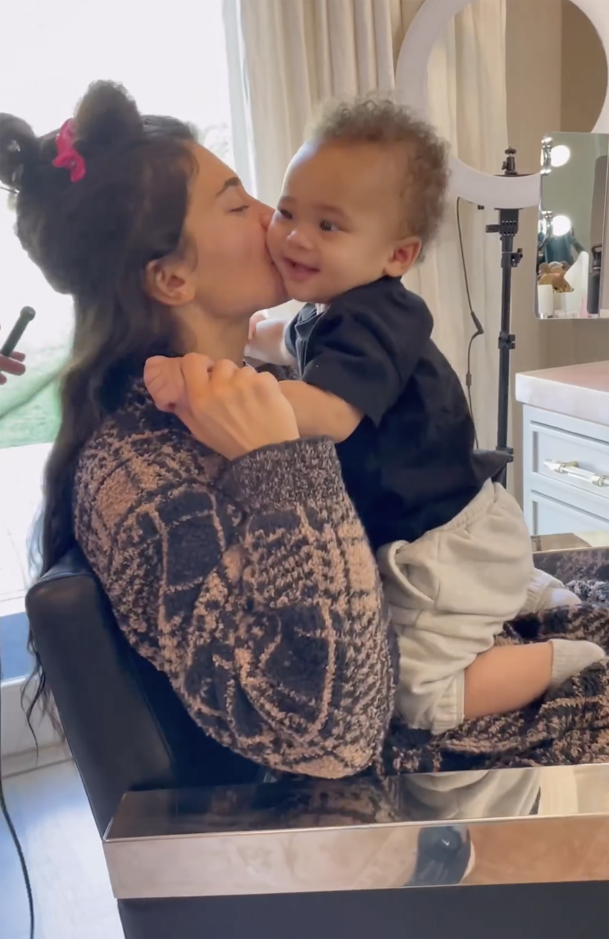 Kylie Jenner kisses her son Aire on the cheek.