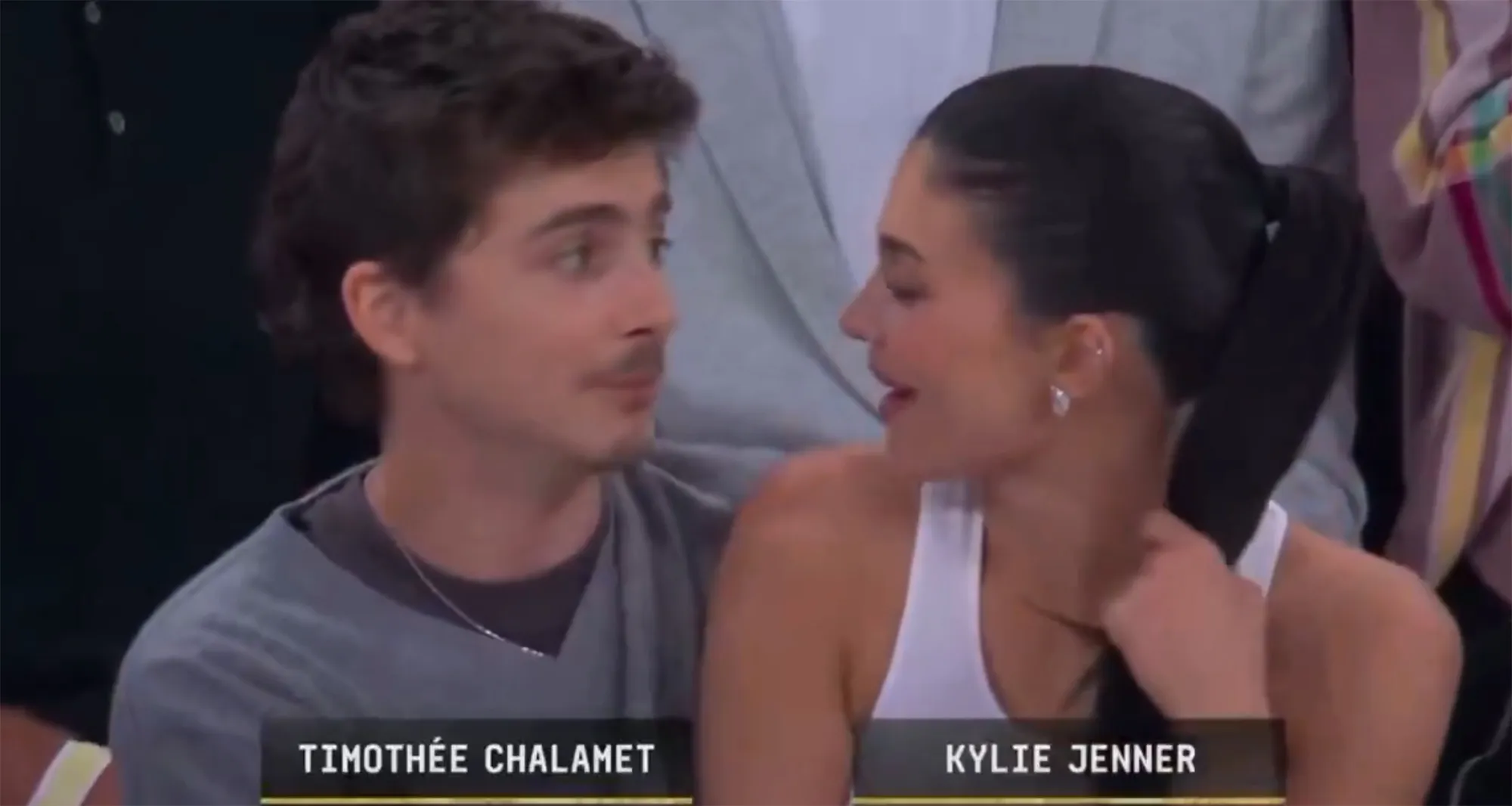 Timothée Chalamet and Kylie Jenner leaning in to kiss each other at a Knicks game.