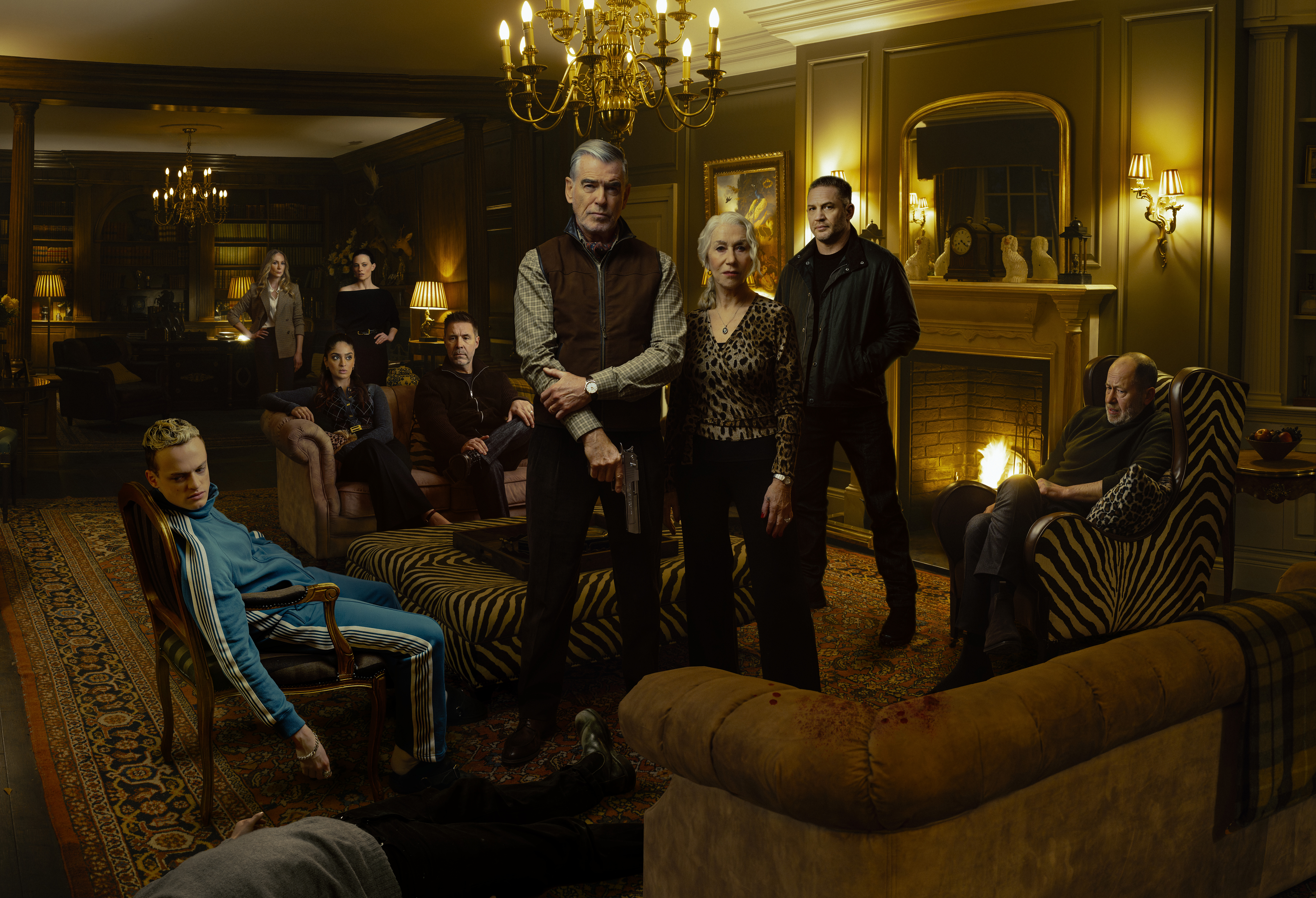 Collage of Anson Boon as Eddie Harrigan, Joanne Froggatt as Jan Da Souza, Mandeep Dhillon as Seraphina Harrigan, Lara Pulver as Bella Harrigan, Paddy Considine as Kevin Harrigan, Pierce Brosnan as Conrad Harrigan, Helen Mirren as Maeve Harrigan, Tom Hardy as Harry Da Souza, and Daniel Betts as Brendan Harrigan in MOBLAND, season 1.