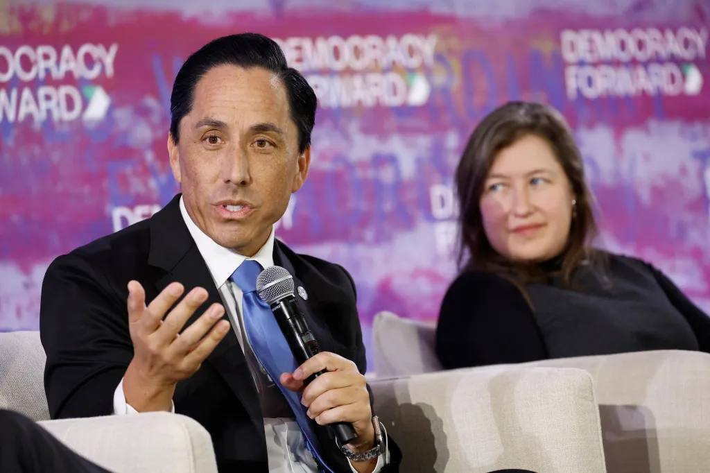 San Diego Mayor Todd Gloria speaking at an event with Jessica Floyd of The Hub Project sitting next to him.
