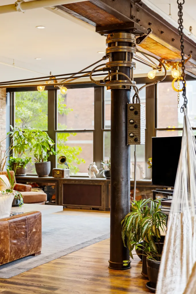 The apartment features an ultra-industrial aesthetic with exposed brick, steel columns, timber beams and oversized warehouse-style windows that flood the space with natural light.