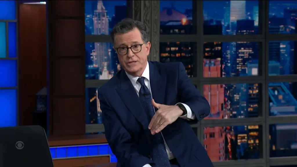 Stephen Colbert on the set of The Late Show with Stephen Colbert, gesturing with his hands.