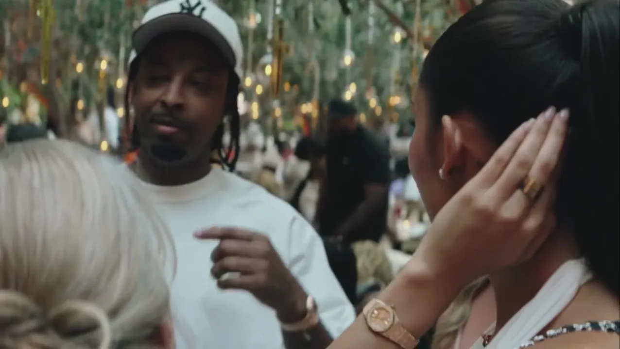 21 Savage and Latto in a blurred outdoor setting.