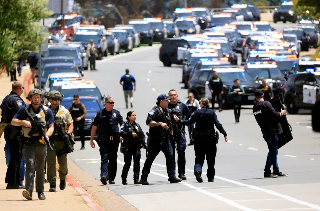 Law enforcement officers escort people away from the Islamic Center of San Diego after reports of a shooting.