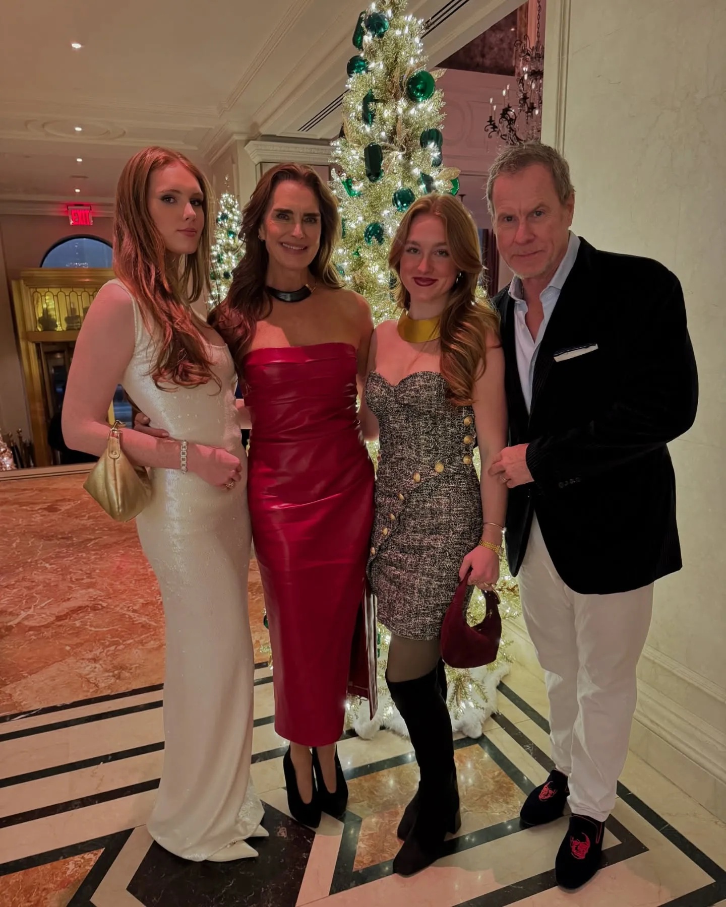 Brooke Shields and her husband Chris Henchy pose with their daughters Grier and Rowan by a Christmas tree.
