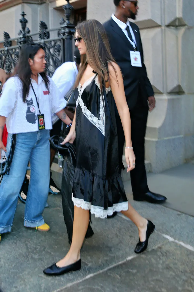 Vittoria Ceretti wears a black satin lace slip midi dress and black ballet flats.