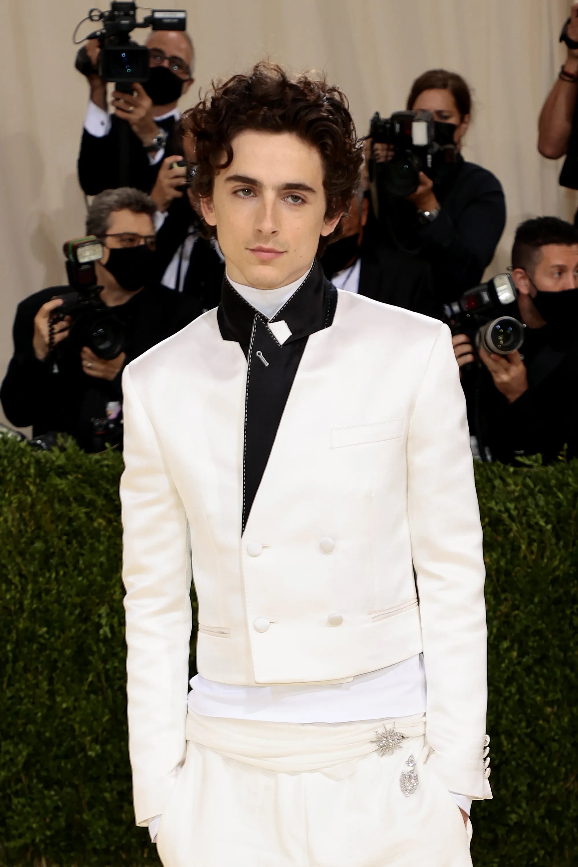 Timothée Chalamet in an all-white tuxedo with a black lapel at the 2021 Met Gala.