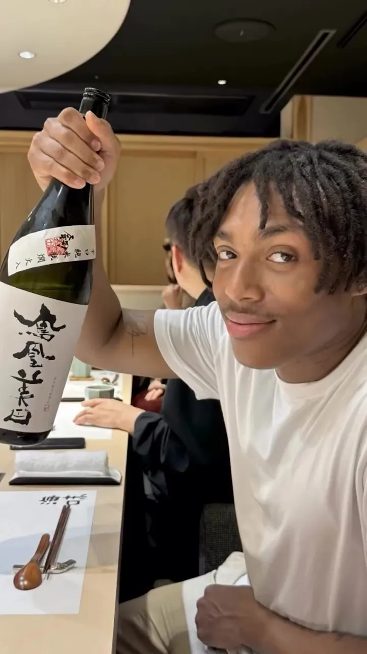 Nathan holding a bottle of sake in Japan.