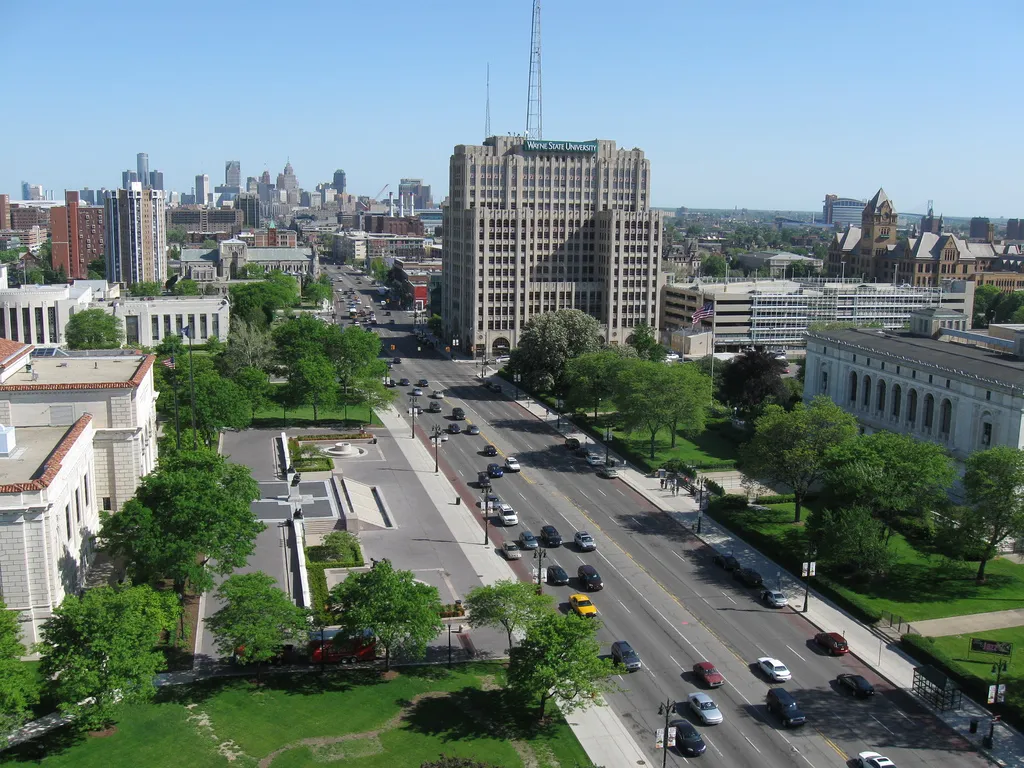 View looking down Woodward Avenue in Detroit, showing the Detroit Institute of Arts, Detroit Public Library, and the downtown skyline in the background.