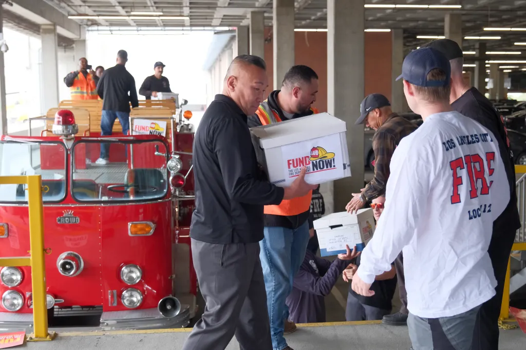 People gather with boxes of petitions that read 