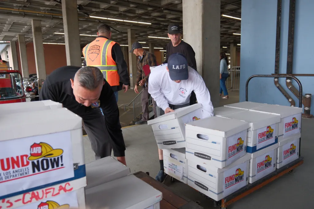 Los Angeles firefighters gather boxes of signed petitions for a ballot measure.