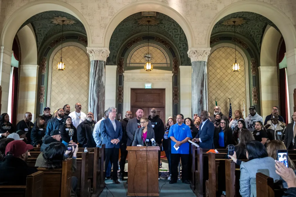 Los Angeles Mayor Karen Bass speaking at a press conference at City Hall, flanked by community leaders.