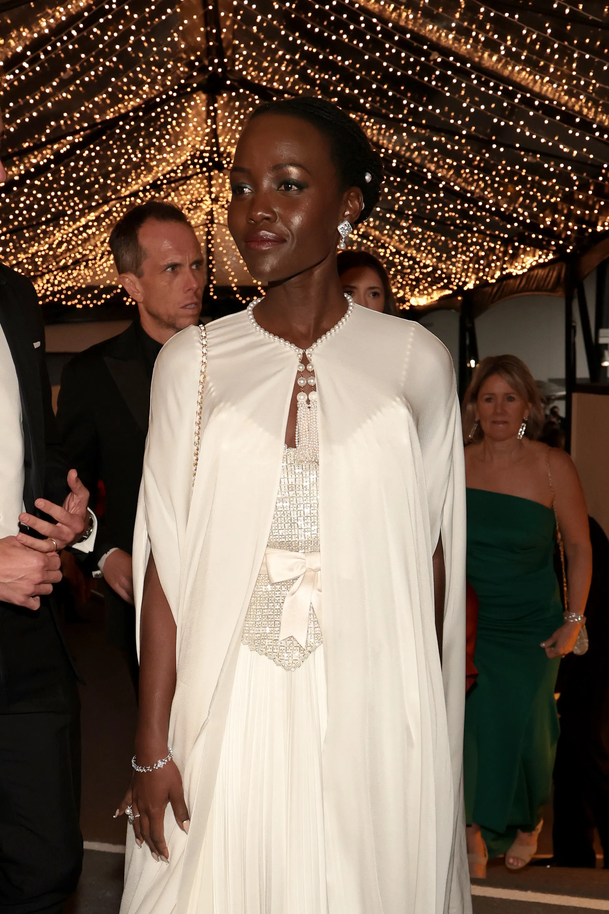 Lupita Nyong'o in a white gown with a beaded bodice and pearl necklace at the 97th Annual Oscars Governors Ball.