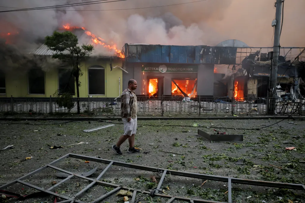 A man walks past burning buildings after a Russian missile and drone strike in Kyiv.