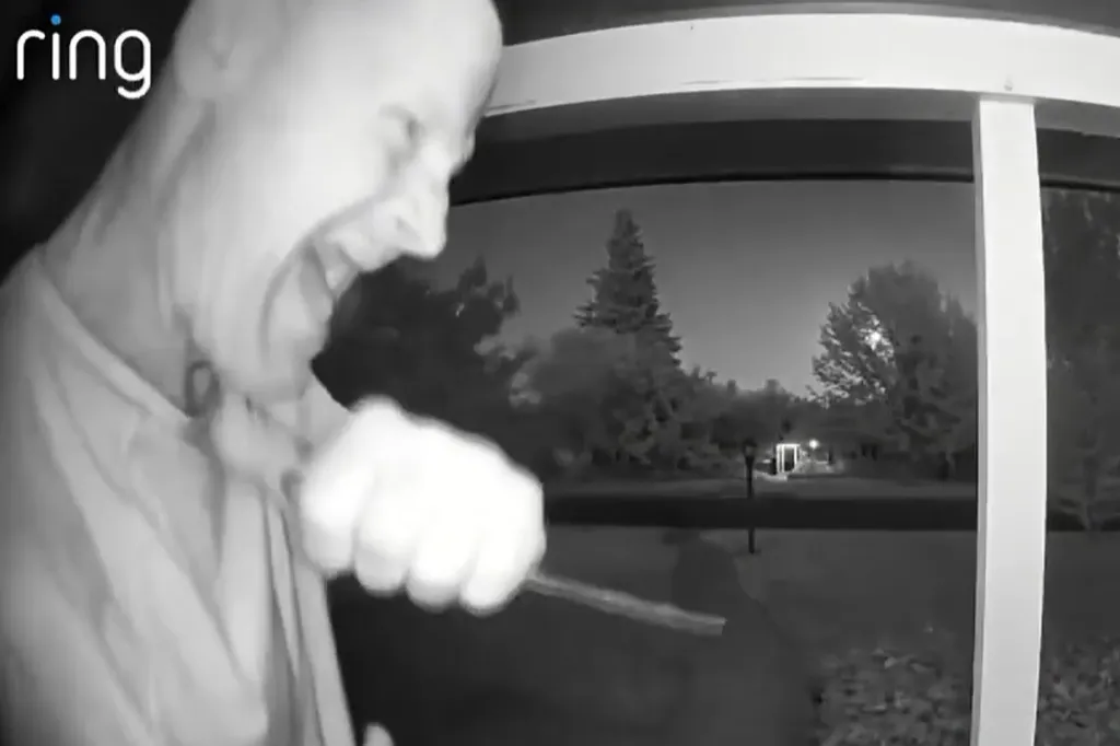 A man on a doorbell camera making repeated stabbing motions with a knife.