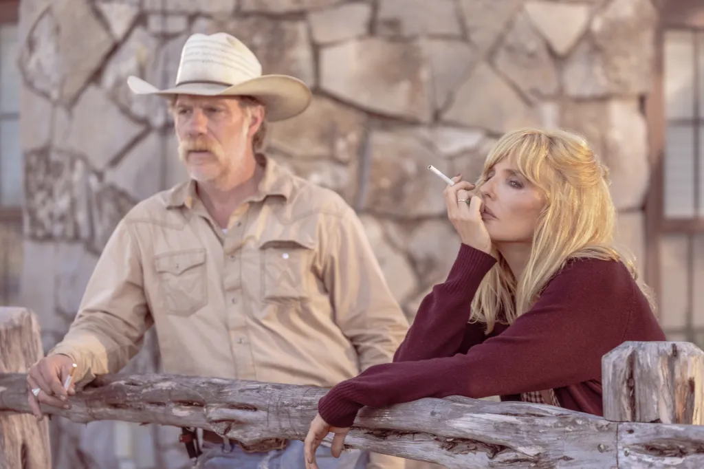 Marc Menchaca as Zachariah and Kelly Reilly as Beth Dutton leaning on a wooden fence.