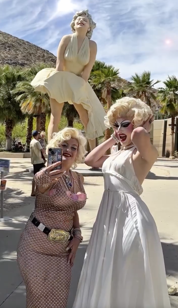 Two Marilyn Monroe impersonators posing with a large Marilyn Monroe statue in Palm Springs, California.