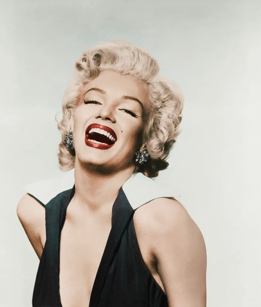 Head and shoulders portrait of Marilyn Monroe laughing.