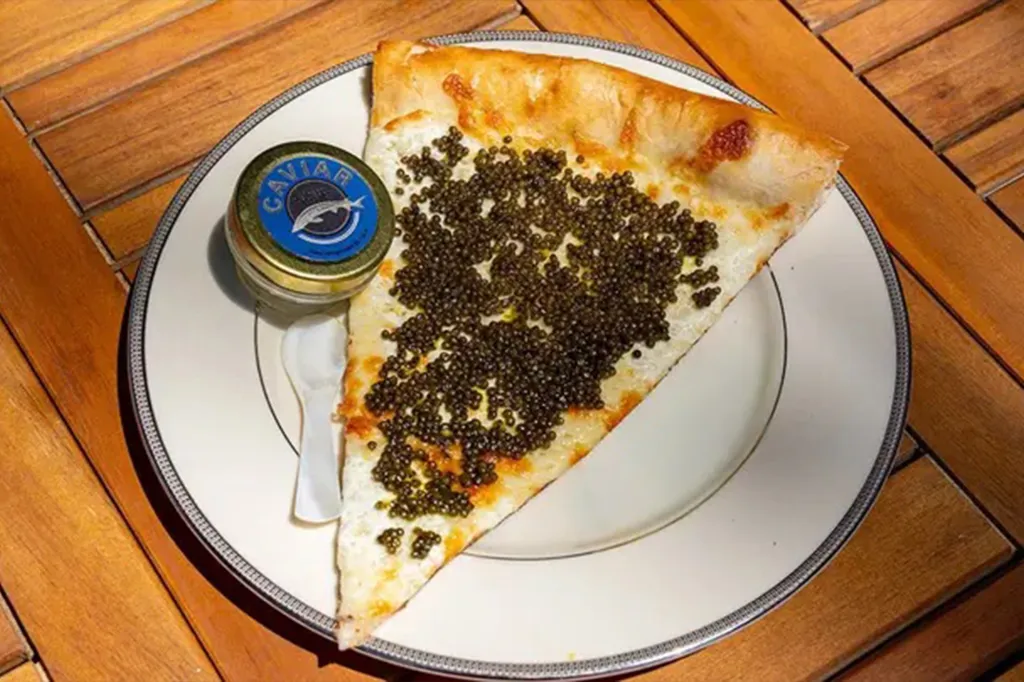 Marina's caviar pizza slice with a tin of caviar and spoon.