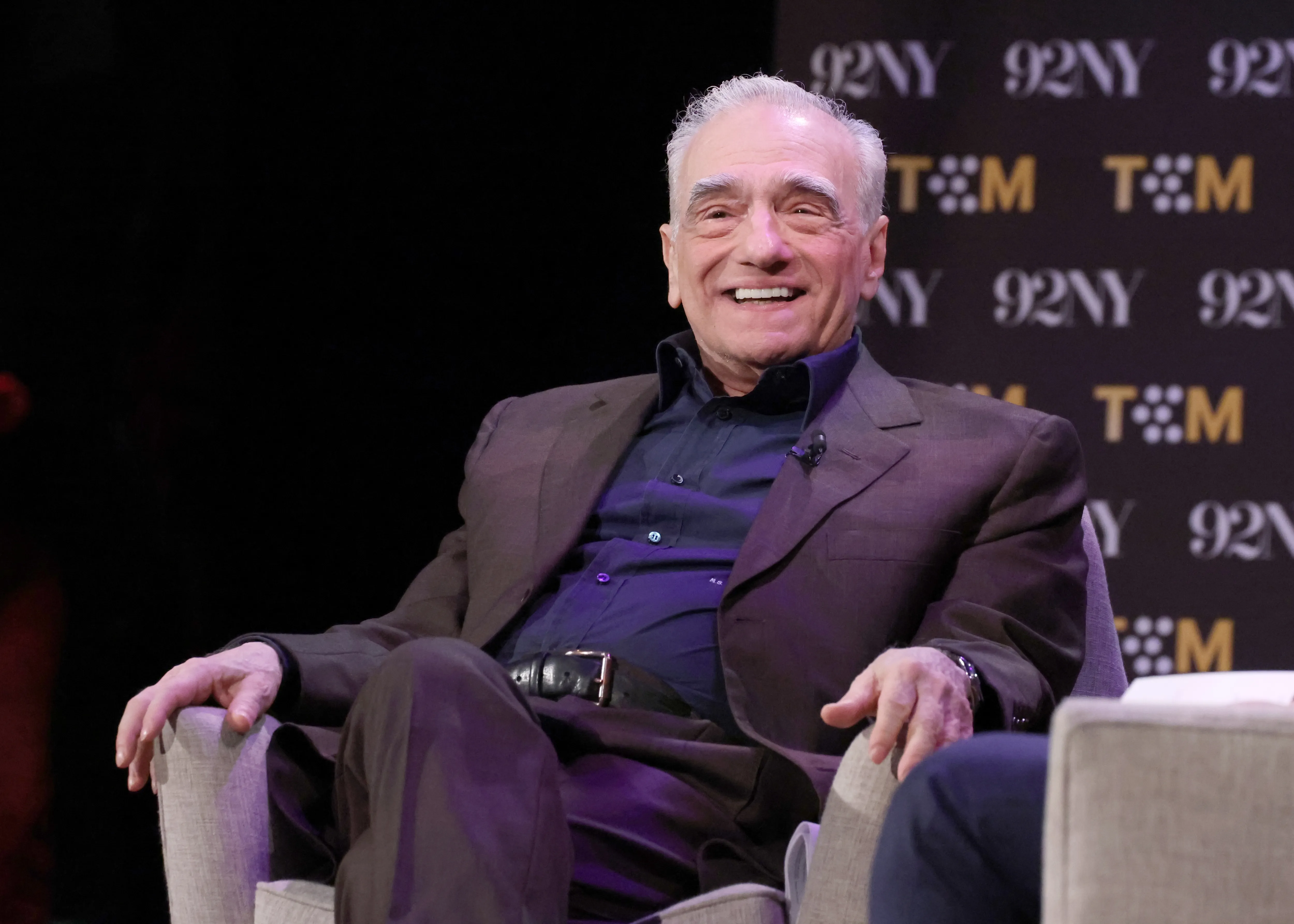 Martin Scorsese smiles while sitting on stage at TCM event.