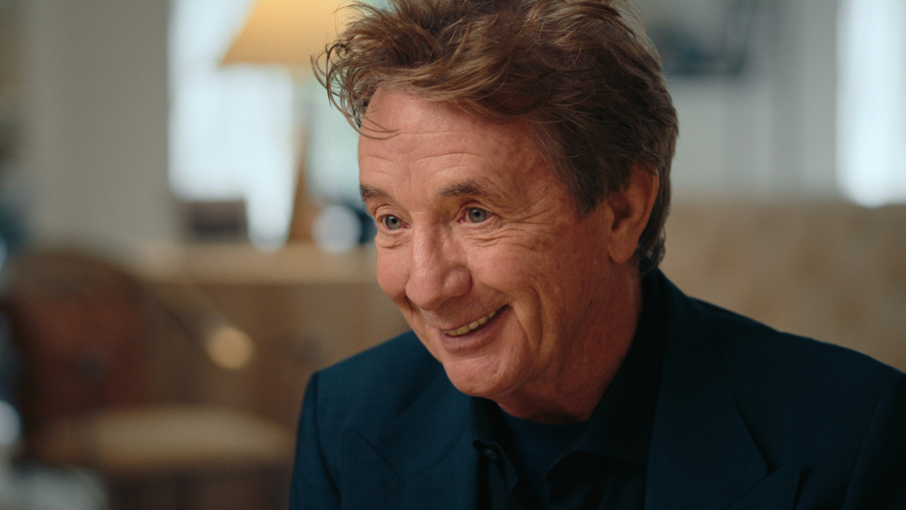 Young Martin Short sits with his mother and father, his arm in a sling.