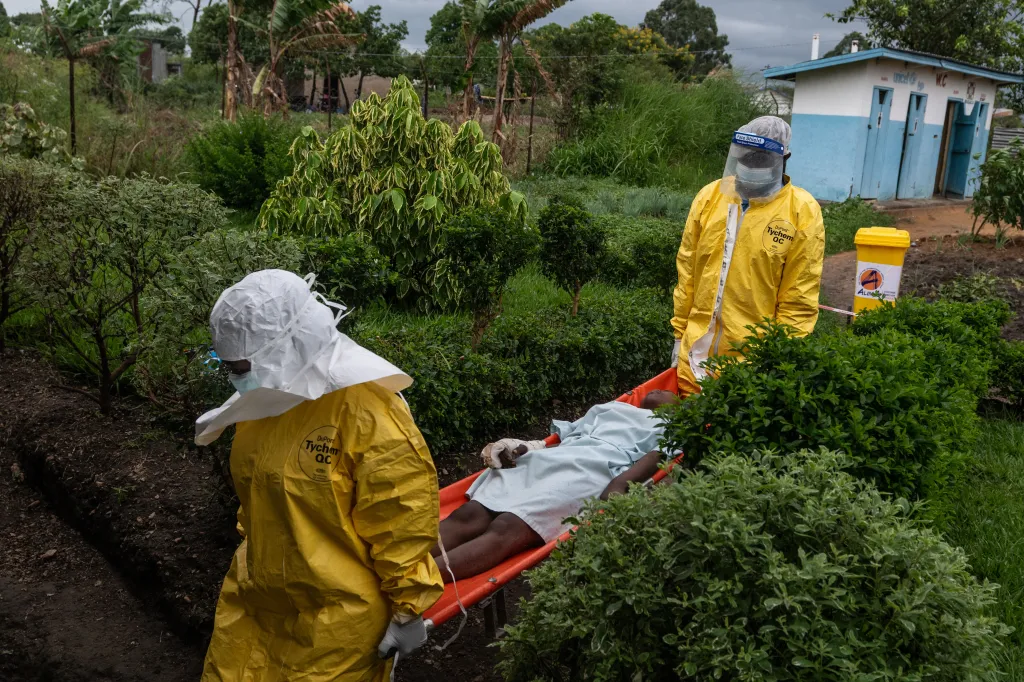 Medical staff in hazmat suits carrying an Ebola patient on a stretcher to a treatment center in Congo.