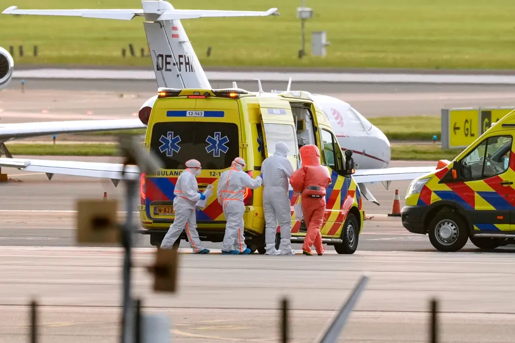 Medics escort a patient evacuated from a cruise ship with suspected hantavirus infection to an ambulance at Schiphol airport.