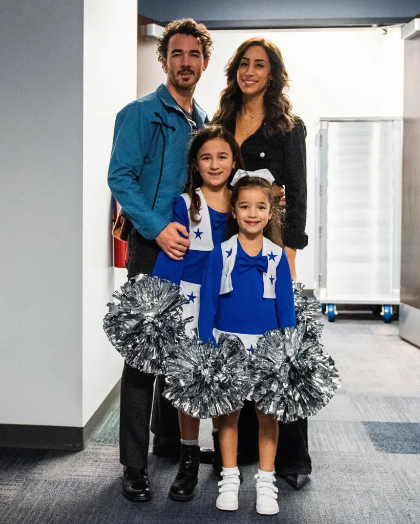 Kevin and Danielle Jonas with their daughters, Valentina and Alena, dressed as cheerleaders.