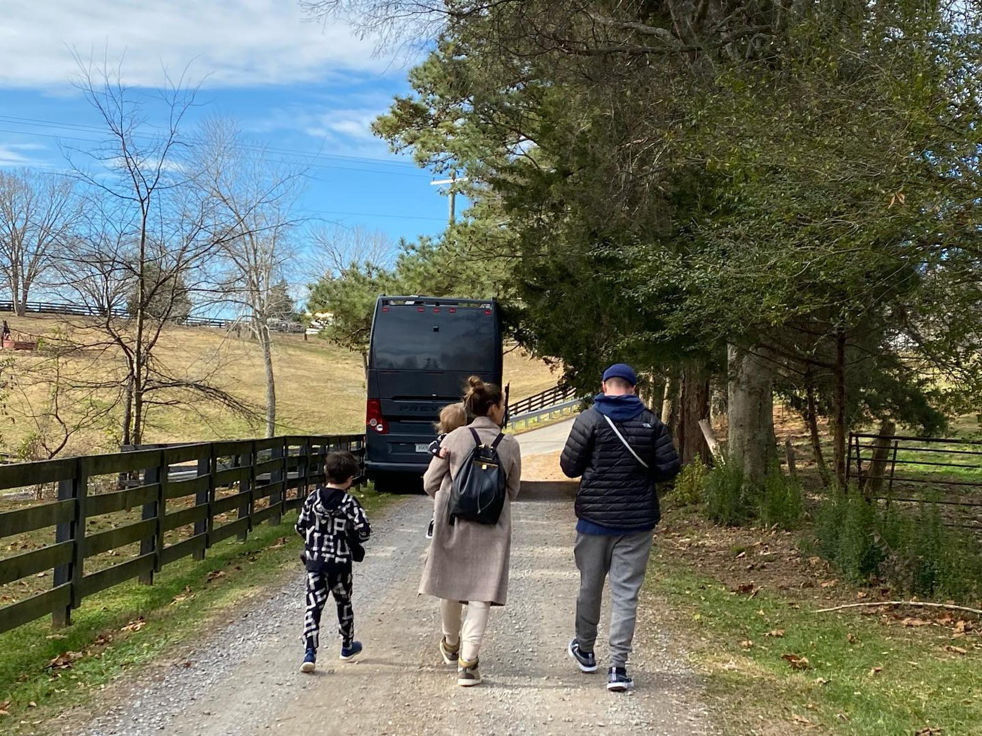 Justin Timberlake and Jessica Biel walking with their two children, Silas and Phineas, on a gravel road.