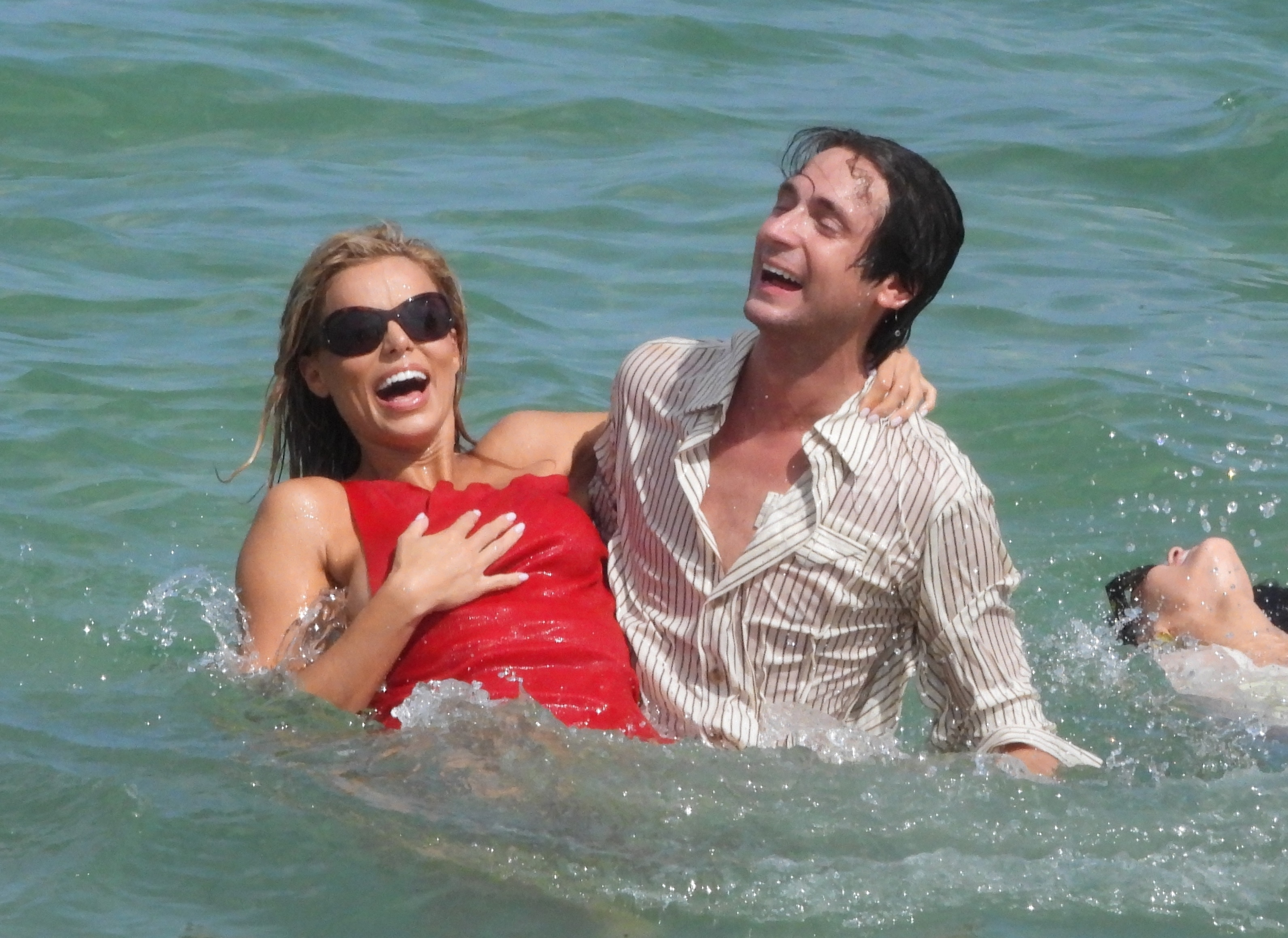 Brooks Nader laughing in the ocean with a man.