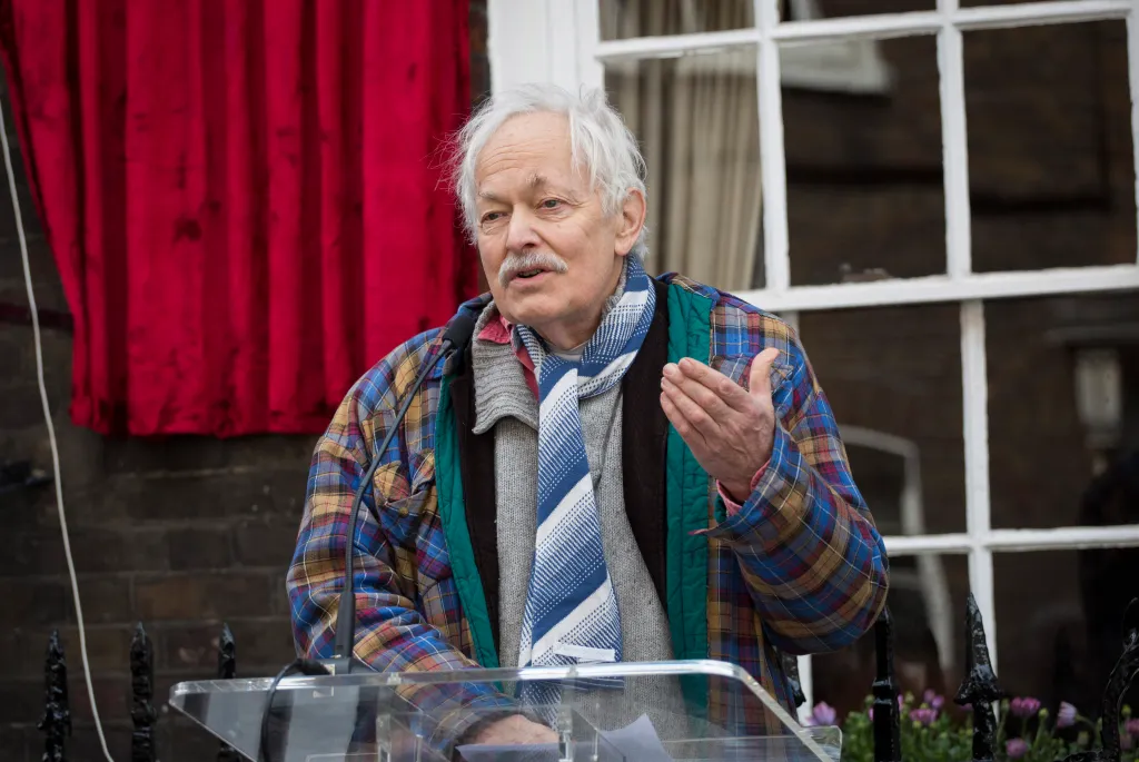 Michael Pennington speaking at a podium during the unveiling of a new plaque.