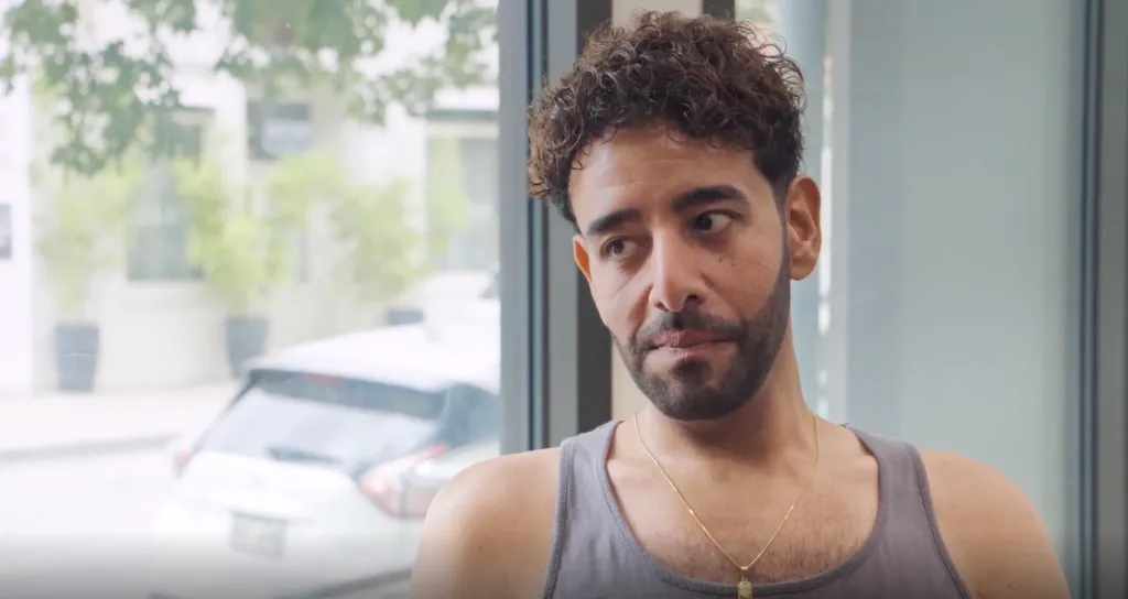 Mido looking sideways with a slight frown.