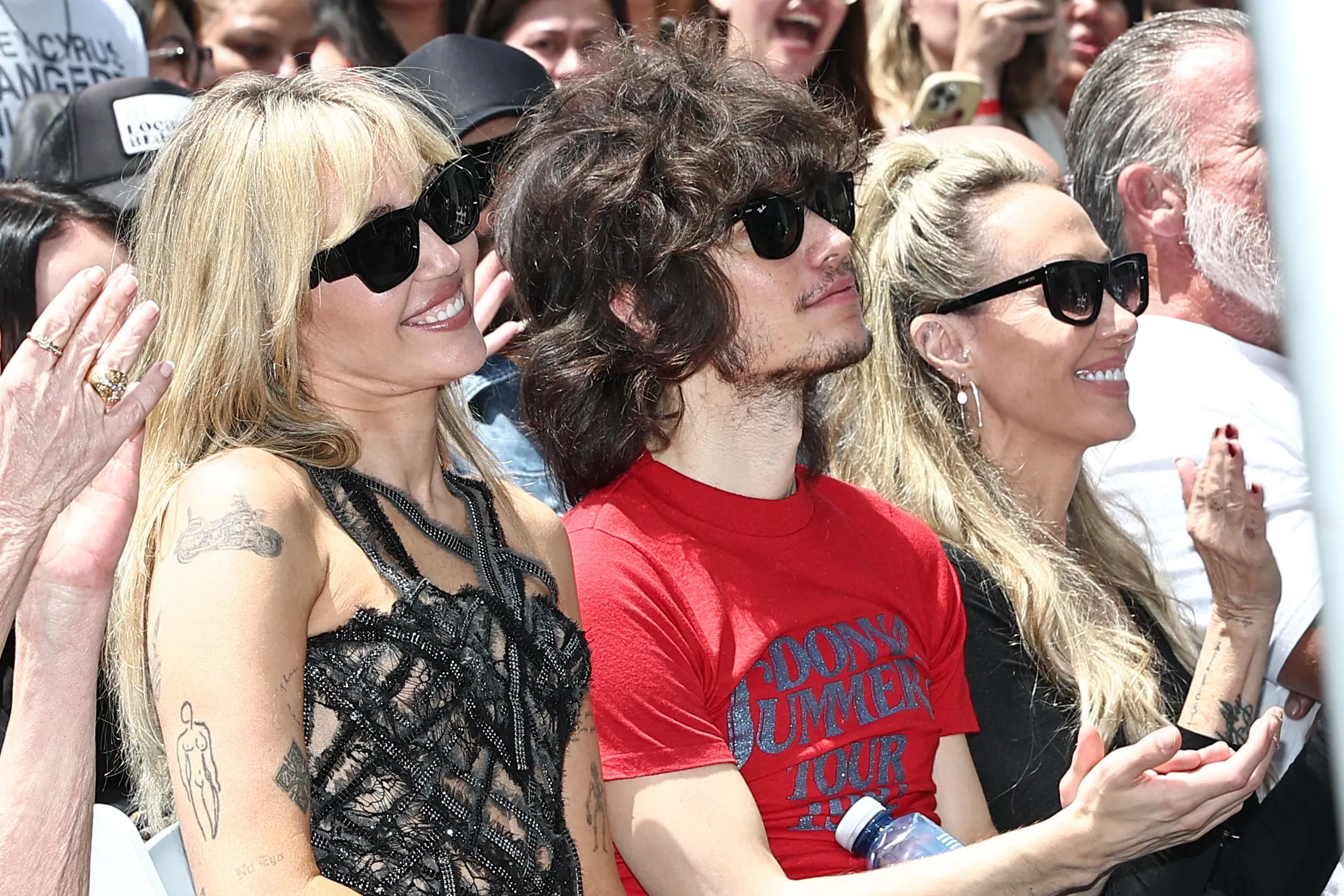 Miley Cyrus, Maxx Morando, and Tish Cyrus-Purcell are seated side-by-side.