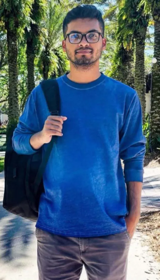 Young man in a blue shirt with a backpack.